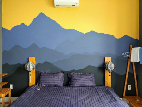 sypialnia z górskim malowidłem na ścianie w obiekcie Ly Ly River w Hoi An