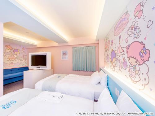 a bedroom with two beds and a wall with hello kitty paintings at HOTEL OKINAWA WITH SANRIO CHARACTERS in Naha