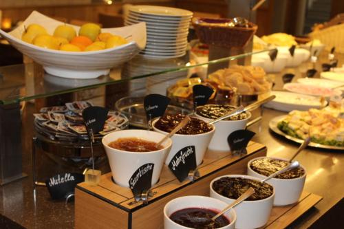 a buffet with bowls of food on a table at DAS HUDEWALD Hotel & Resort in Ueckeritz