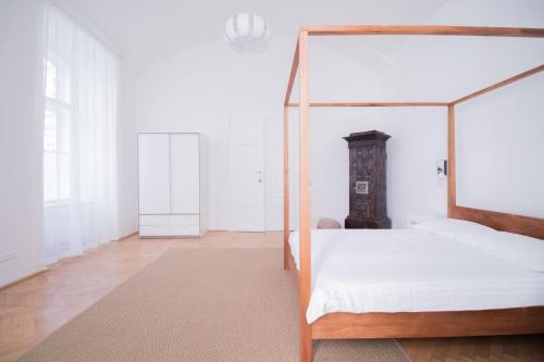 1 dormitorio con 1 cama con marco de madera en HeyMi Apartments Stadtpark, en Viena