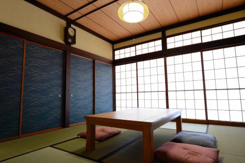 Guesthouse Iwase في توياما: غرفة مع طاولة وبعض النوافذ