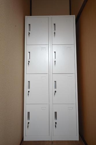 two white cabinets sitting next to a wall at Guesthouse Iwase in Toyama