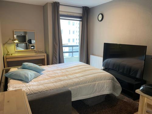 - une chambre avec un lit, un miroir et une fenêtre dans l'établissement Chez edGARE à Chambéry, à Chambéry