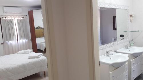 a bathroom with two sinks and a mirror and a bed at La stanza del paradiso in Torre Pali 