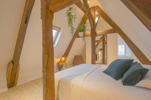 a bedroom with a white bed with wooden beams at Victoire Duplex atypique cosy - PLEIN CENTRE HISTORIQUE BAYEUX PROCHE RESTAURANTS COMMERCES- LUMINEUX - PARKING GRATUIT A PROXIMITE- proche plages du débarquement, Omaha Beach in Bayeux