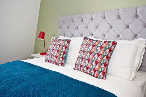 a bedroom with a white bed with two pillows at Interlude House E Penthouse by City Living London in London
