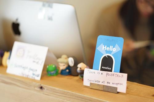 a table with hello sign and a book on it at Santiago Guesthouse Hiroshima in Hiroshima