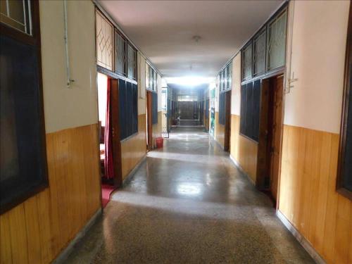 pusty korytarz budynku z drewnianymi podłogami i drzwiami w obiekcie Lalazar hotel w mieście Abbottabad