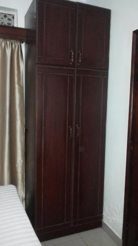 a bedroom with wooden cabinets and a bed at The Pearl Inn in Koboko