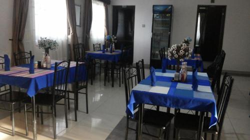 a room with blue tables and chairs with flowers on them at The Pearl Inn in Koboko