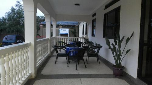 a porch with a table and chairs on it at The Pearl Inn in Koboko
