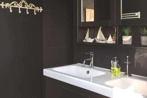a bathroom with a white sink and a mirror at Le Petit Lupin in Saint-Coulomb