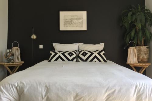 a bedroom with a large white bed with two pillows at Le Petit Lupin in Saint-Coulomb