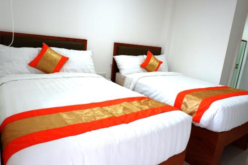 a bedroom with two beds with red and white sheets at Arawa Traveller's Inn Motel in Makassar