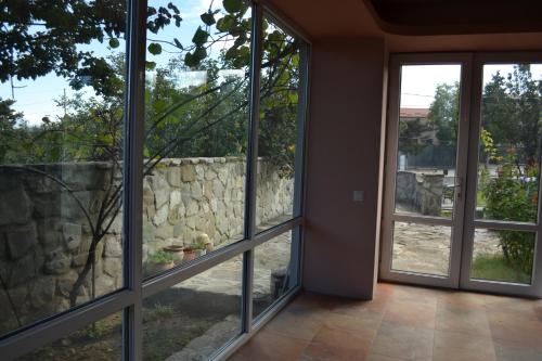 a room with large windows and a stone wall at Royal Telavi in Tʼelavi