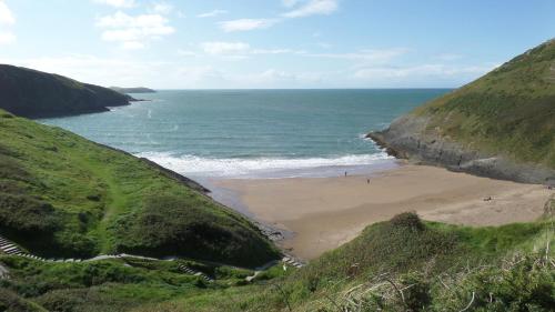 a beach with people on the sand and the ocean at Pant Glas in Cardigan