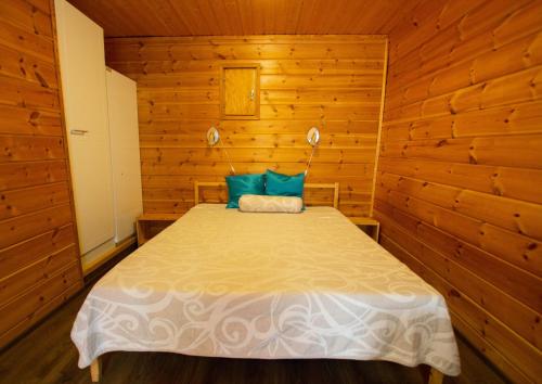 a bedroom with a bed in a wooden cabin at Motelli Rovaniemi in Rovaniemi