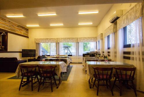 a dining room with tables and chairs and windows at Motelli Rovaniemi in Rovaniemi