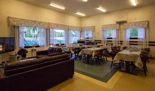 a living room with tables and chairs and a dining room at Motelli Rovaniemi in Rovaniemi