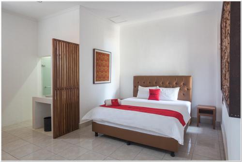 a bedroom with a large bed and a bathroom at Koolkost near Padang Galak Beach in Denpasar