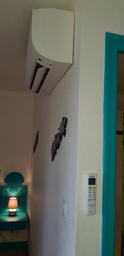 a room with a white refrigerator and a light on the wall at Les Hauts De Caritan in Sainte-Anne