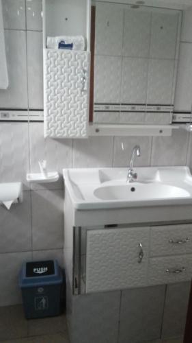 a white bathroom with a sink and a mirror at The Pearl Inn in Koboko
