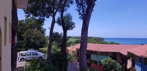 a white van parked next to a building with trees at Les Hauts De Caritan in Sainte-Anne