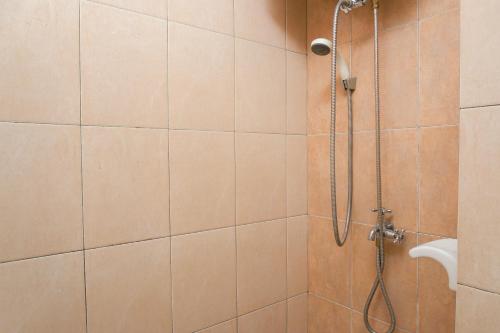 a bathroom with a shower with a shower head at Elegant Studio Apartment at Margonda Residence 2 By Travelio in Depok