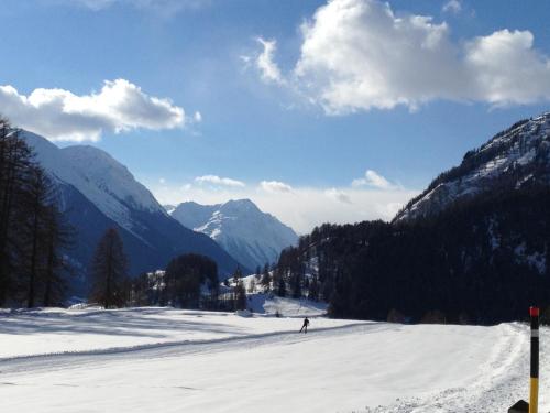 a person skiing down a snow covered slope in the mountains at Moderne helle Ferienwohnung 1-6 Pers - Chasa32 in Guarda in Guarda