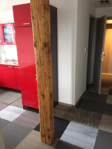 a wooden pole in a kitchen with red cabinets at chalupa na Samotě s vířivkou in Tábor