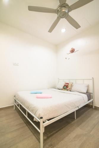 a bed in a room with a ceiling fan at Landed Cozy House Near SPICE, Airport in Kampong Manggis