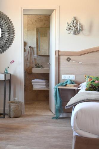 a bedroom with a bed and a mirror at Hôtel Villa Glanum et Spa in Saint-Rémy-de-Provence