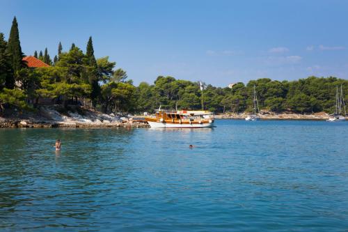 a person swimming in the water near a boat at Remisens Hotel Albatros-All inclusive in Cavtat