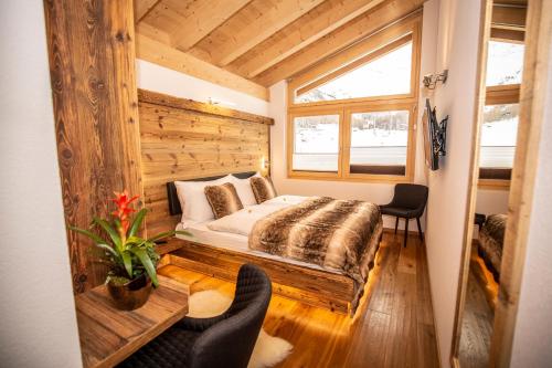 a bedroom with a bed and a wooden wall at Palace Luxury Wellness Apartment and Boutique Hotel Ski-in-out in Saas-Fee