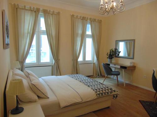 Apartments Radićeva في زغرب: غرفة نوم بسرير ومكتب ونوافذ