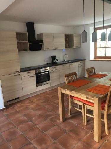 a kitchen with a wooden table and a table and chairs at Sonnenhof in Limbach im Burgenland