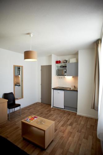 un salon avec une table et une cuisine dans l'établissement UXCO République, à Avignon