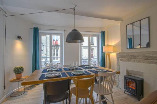 une salle à manger avec une table et des chaises et une cheminée dans l'établissement Freedom Grand Triplex lumineux décoration contemporaine - PLEIN CENTRE HISTORIQUE BAYEUX - PARKING GRATUIT A PROXIMITE PROCHE COMMERCES RESTAURANTS - PLAGES DU DEBARQUEMENT, à Bayeux