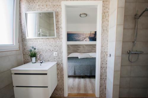 a bathroom with a sink and a mirror and a bed at RCN Vakantiepark de Schotsman Bungalow de Boei in Kamperland