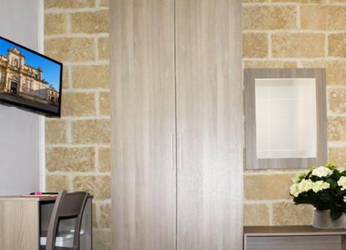 a living room with a television and a brick wall at B&B La Dimora dei Professori in Lecce