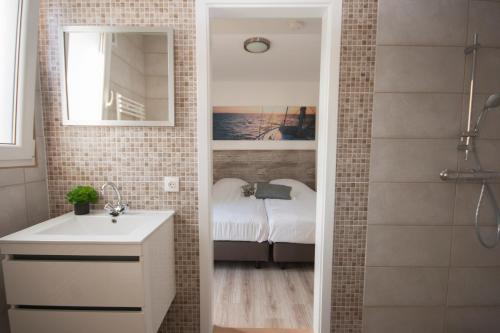 a bathroom with a shower with a sink and a mirror at RCN Vakantiepark de Schotsman Bungalow de Bevelander in Kamperland
