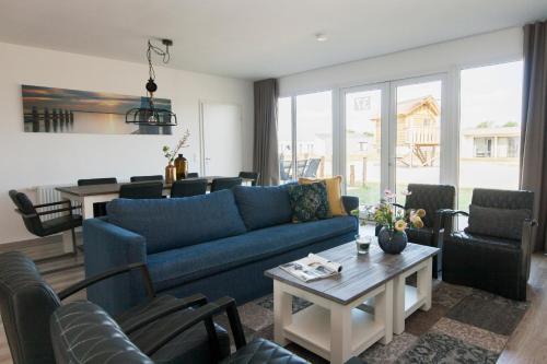 a living room with a blue couch and chairs at RCN Vakantiepark de Schotsman Bungalow de Bevelander in Kamperland