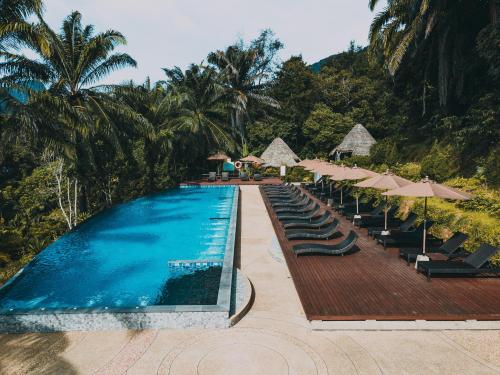 a swimming pool with lounge chairs and umbrellas at Aonang Fiore Resort - SHA Extra Plus in Ao Nang Beach