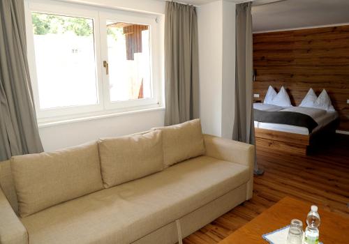 a living room with a couch and a bed at Villa Bucher - Metnitztalerhof in Friesach