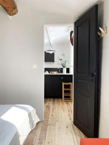 une chambre avec un lit et une porte ouverte dans l'établissement La Magnanerie, à LʼIsle-sur-la-Sorgue