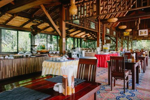 Aonang Fiore Resort - SHA Extra Plus في شاطيء آونانغ: مطعم بطاولات وكراسي في مبنى
