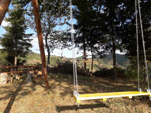 a swing in a park with a table and trees at Turizam Koturovic in Ivanjica