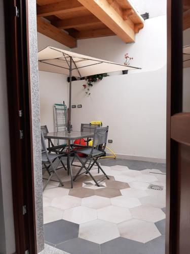 een eetkamer met een tafel en stoelen en een parasol bij Suites de Mar in Santa Teresa Gallura