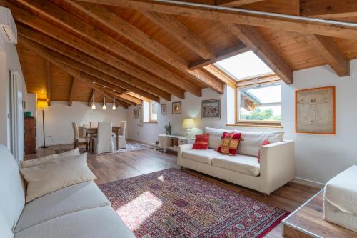 ein Wohnzimmer mit weißen Möbeln und Holzdecken in der Unterkunft Casa di Dino Udine Terenzano in Terenzano
