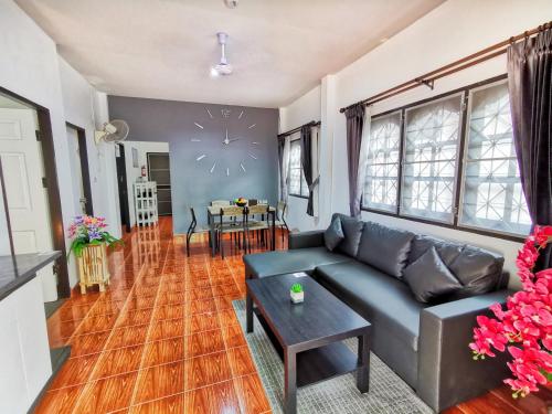 a living room with a couch and a clock on the wall at Thai Orange Villas - Private Pool Villas - Modern & Privacy in Jomtien Beach